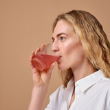 Vanessa Axente drinking the Essa World Collagen from a glass.